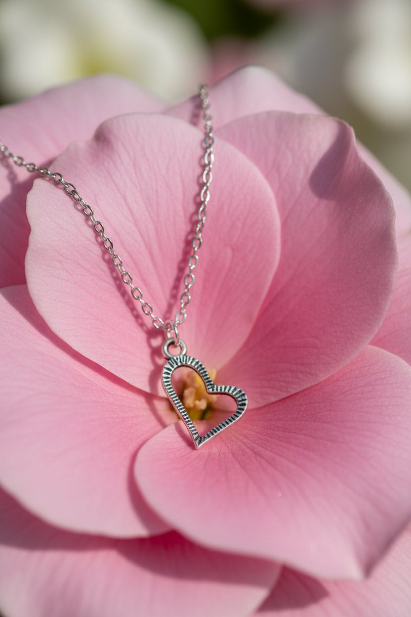 Silver heart-shaped necklace on a large pink flower