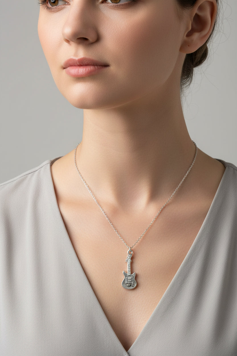 A silver necklace with a guitar-shaped pendant displayed on a model wearing a grey top.