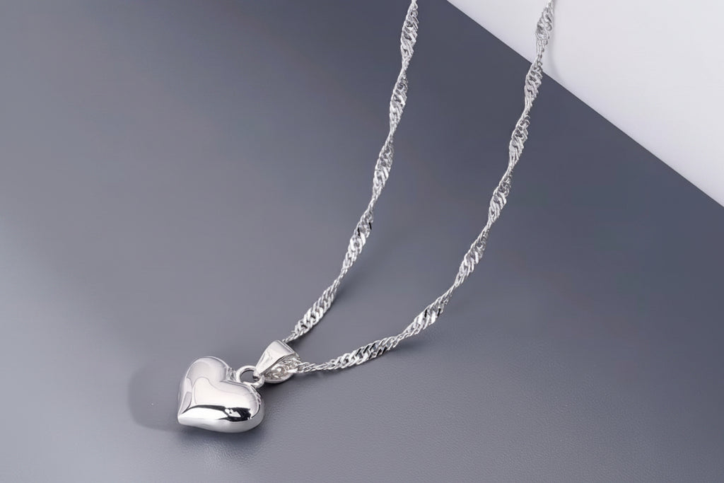 Heart pendant necklace on greyand white background