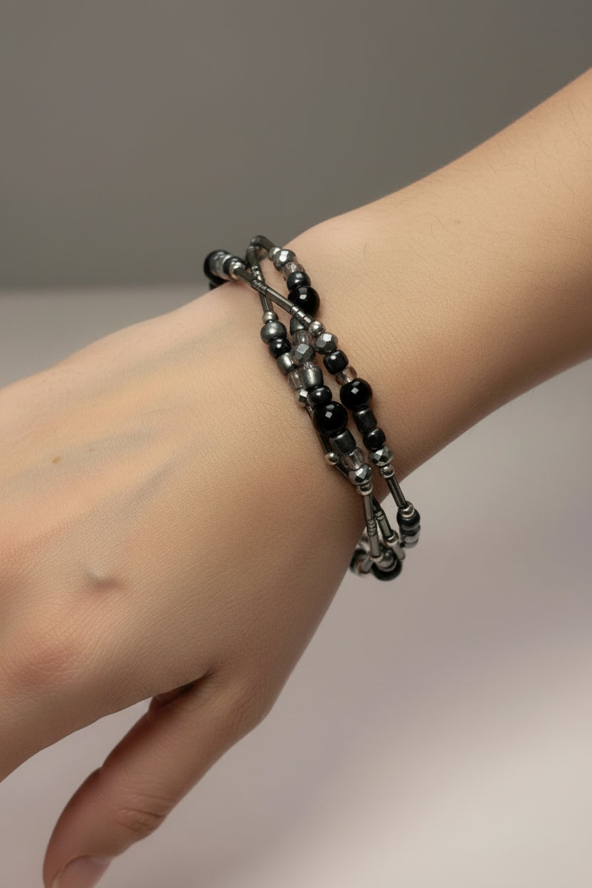 Black beaded triple bracelet set on a model's arm