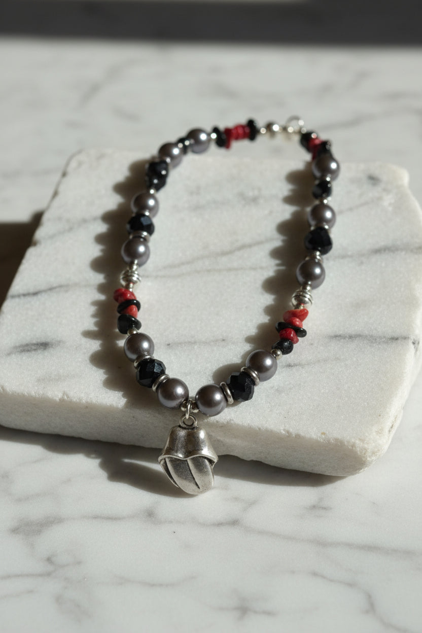 Beaded necklace with a silver charm on a  large white stone