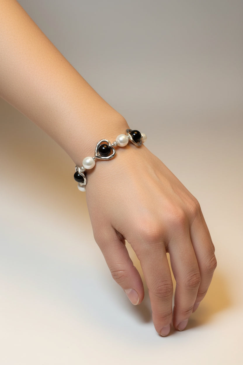 Bracelet with heart and pearl charms on a model