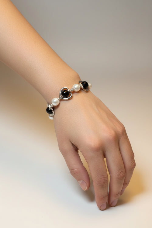 Bracelet with heart and pearl charms on a model