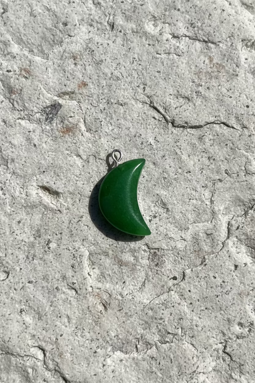 Green crescent moon pendant on a light gray background
