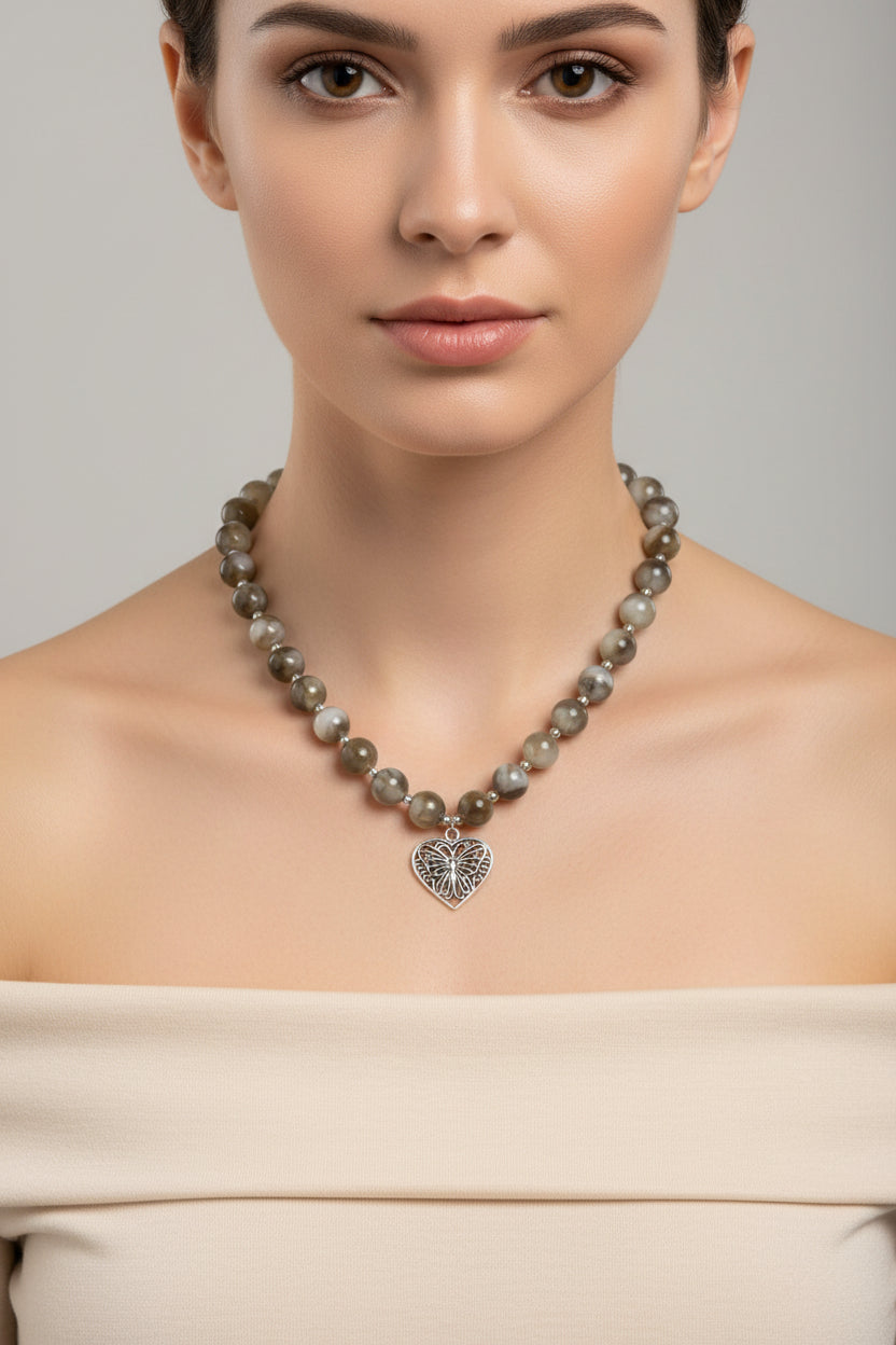 Beaded necklace with a heart-shaped pendant on a model