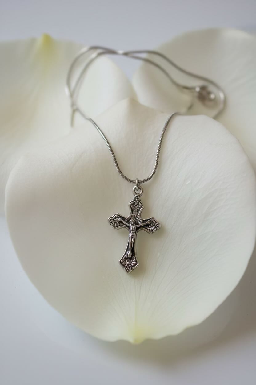 Silver necklace with a cross pendant on a large white petal

