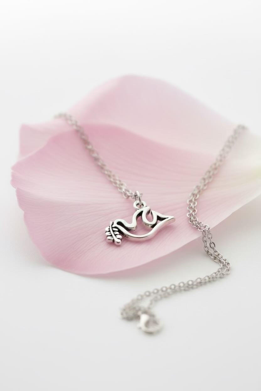 Silver necklace with a dove pendant on a pink rose petal