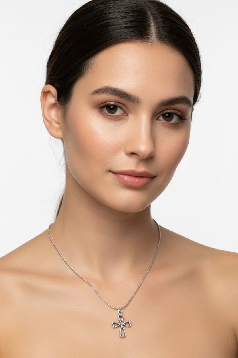 Woman wearing a silver necklace with a cross pendant on a white background