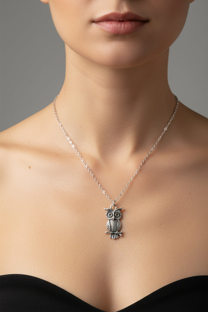 Silver owl necklace on a model 