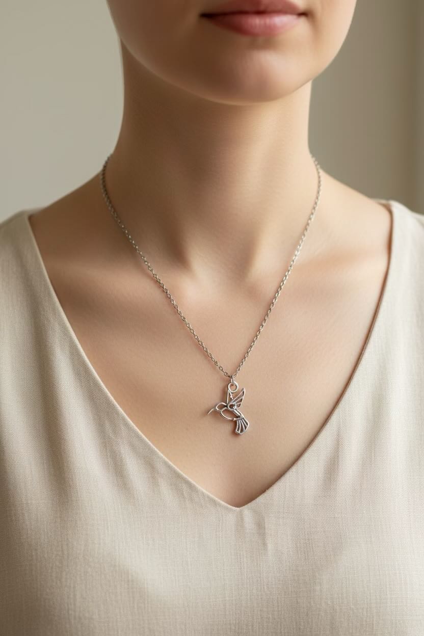 Woodpecker necklace with a delicate pendant worn by a person in a beige top.