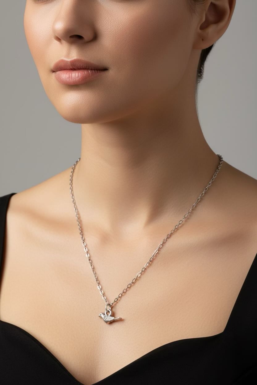 Close-up of a woman wearing a delicate necklace with a small pendant against a neutral background