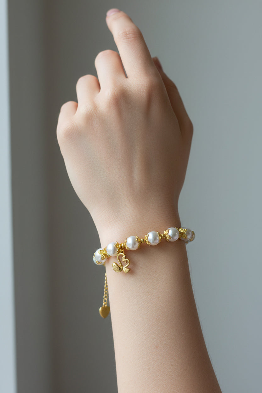 A gold and pearl bracelet displayed on a model's wrist.