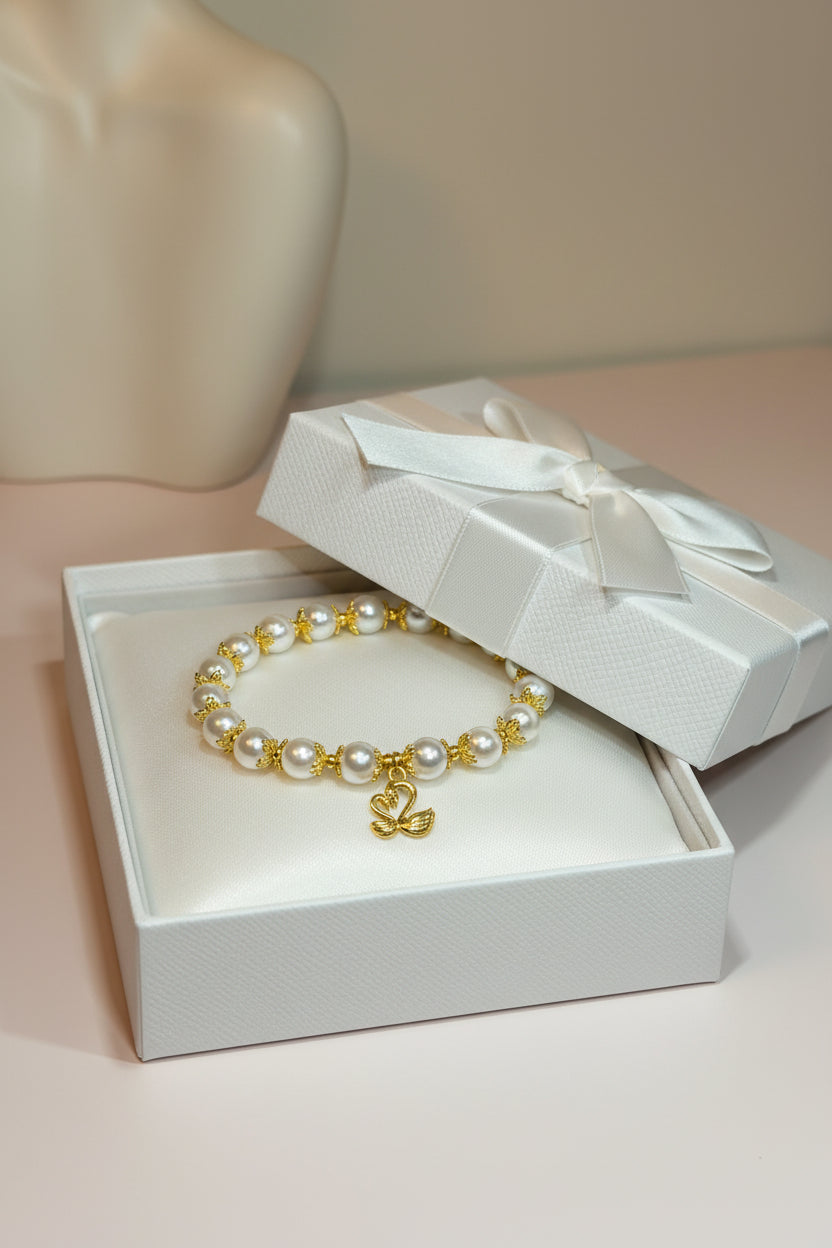 A gold and white pearl bracelet displayed in a gift box.