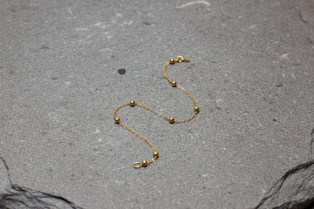Gold bracelet on grey stone