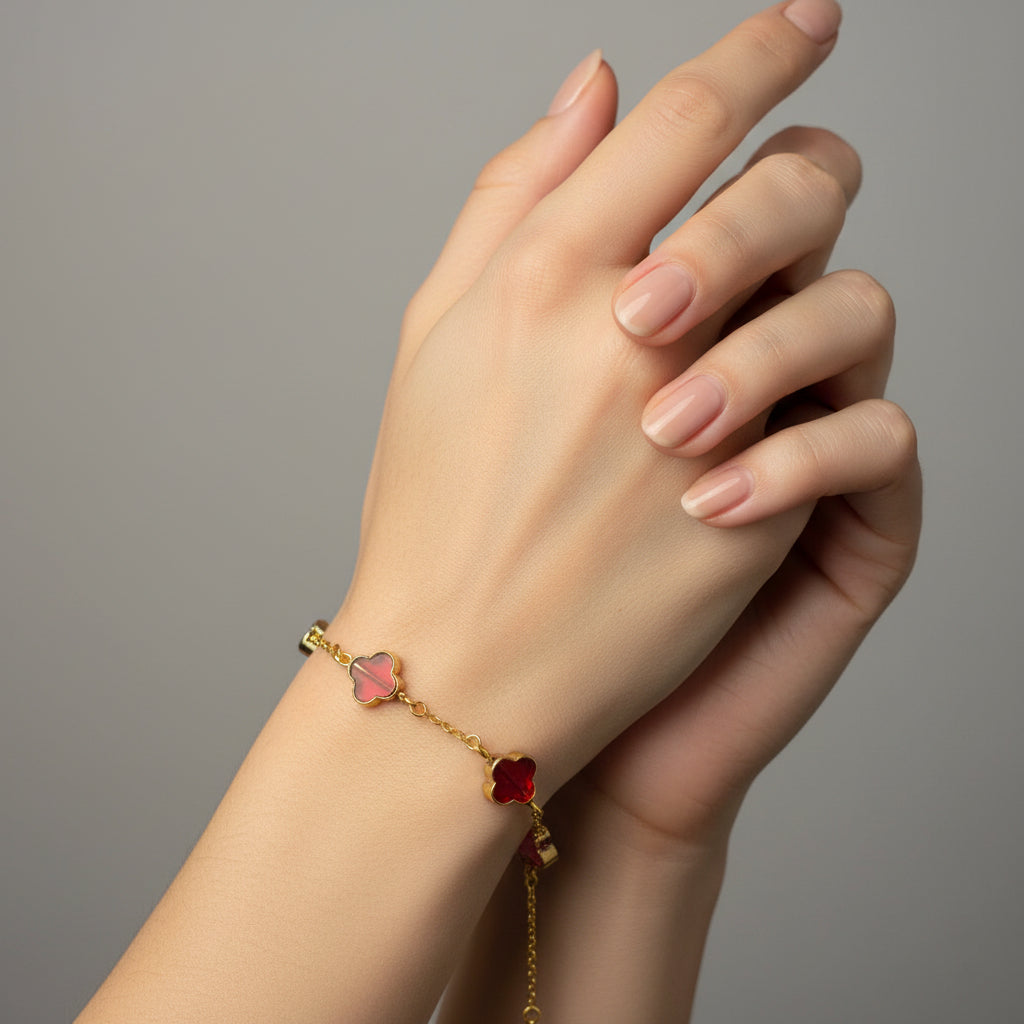 Gold bracelet with red clover charms on a model's wrist