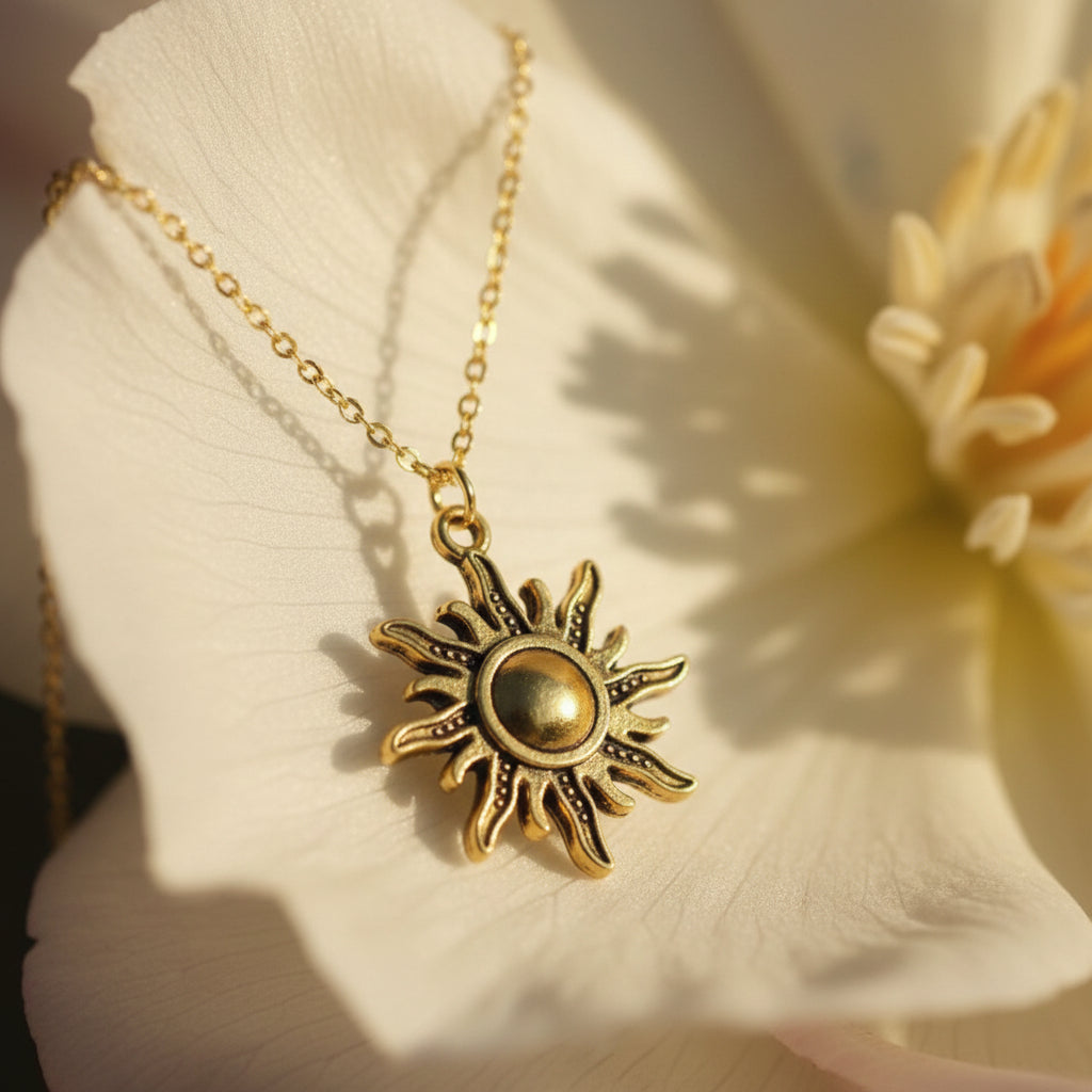 A gold-toned sun pendant necklace displayed on a white mannequin bust against a neutral gray background.