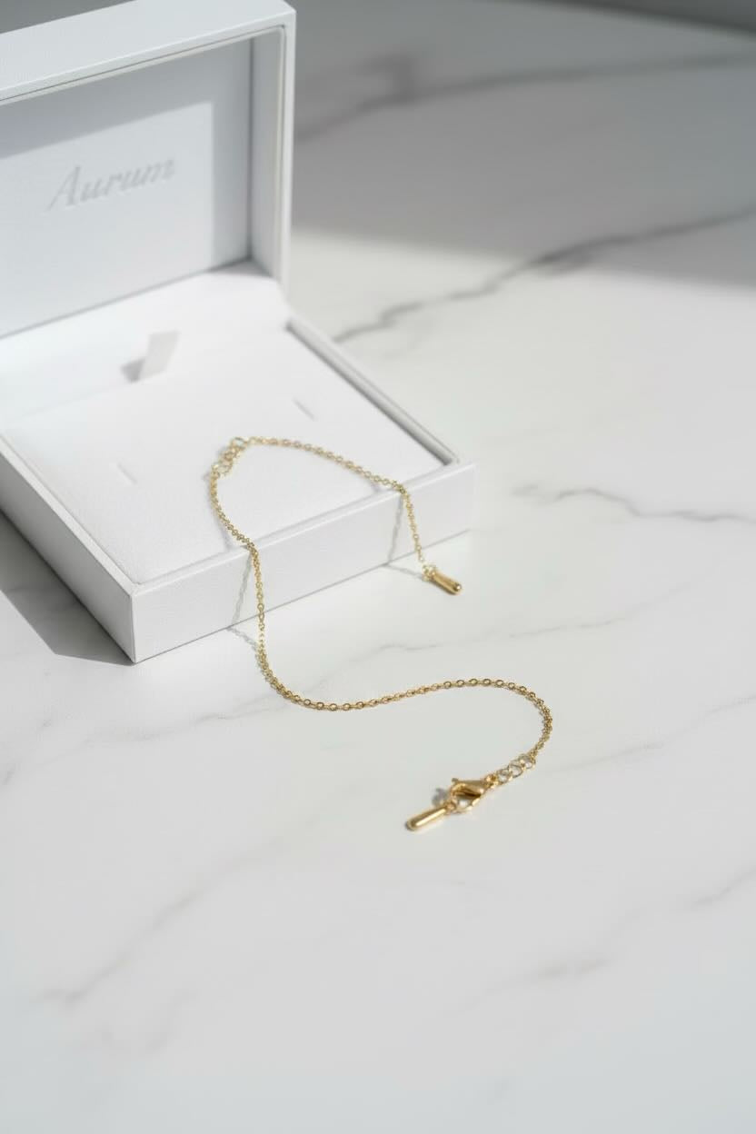 Gold necklace with a clasp on a white marble surface