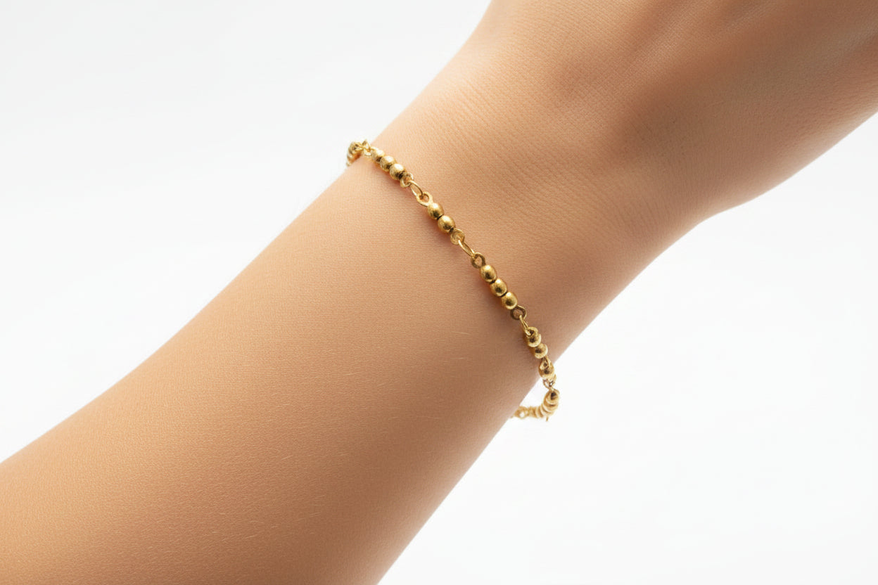 Gold bracelet on a model's arm