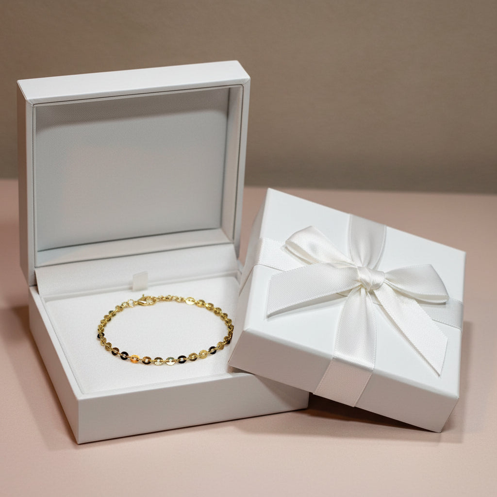 Gold chain bracelet in a white gift box and beige background