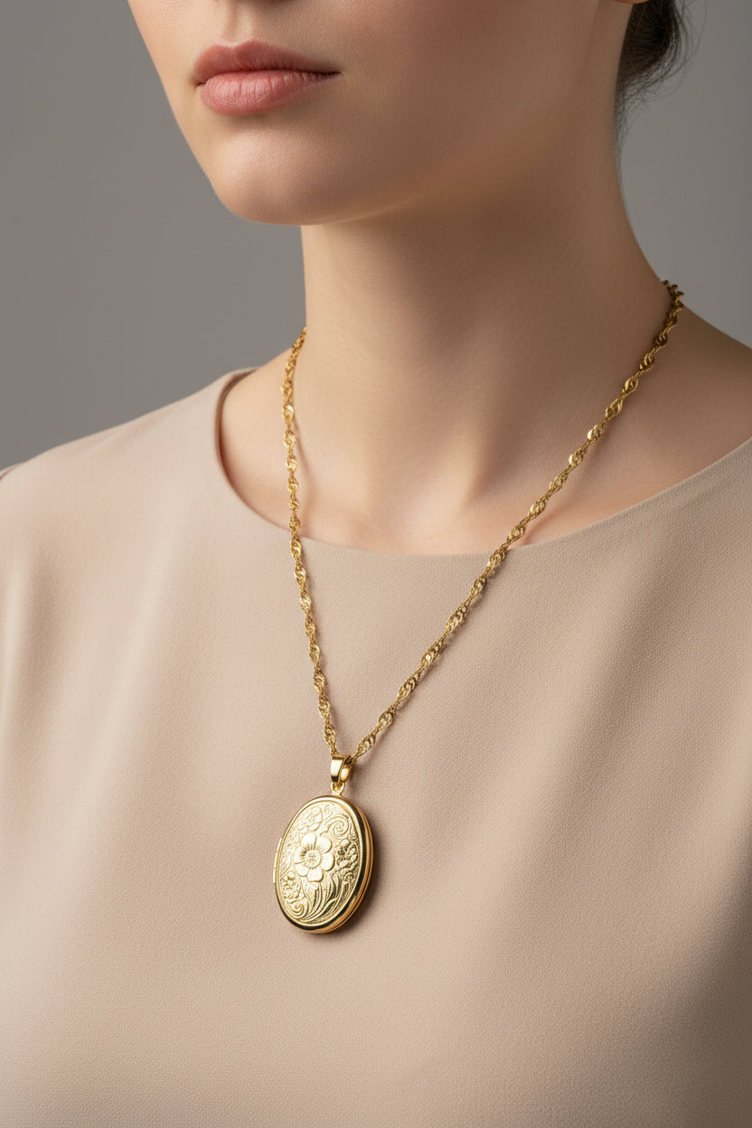 Gold large oval locket necklace with a decorative pendant on a model