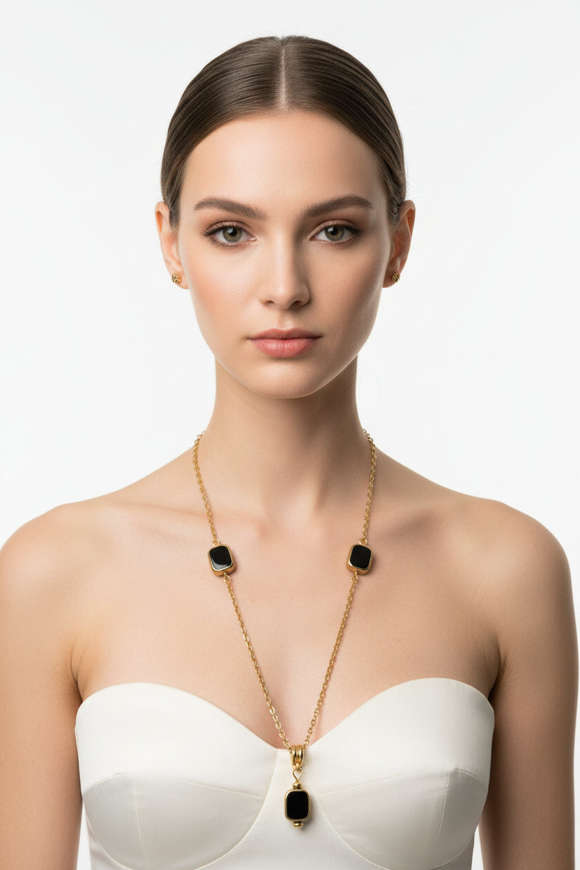 Gold necklace with black charms on a model