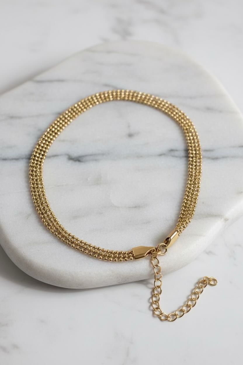 Gold chain necklace on a marble surface