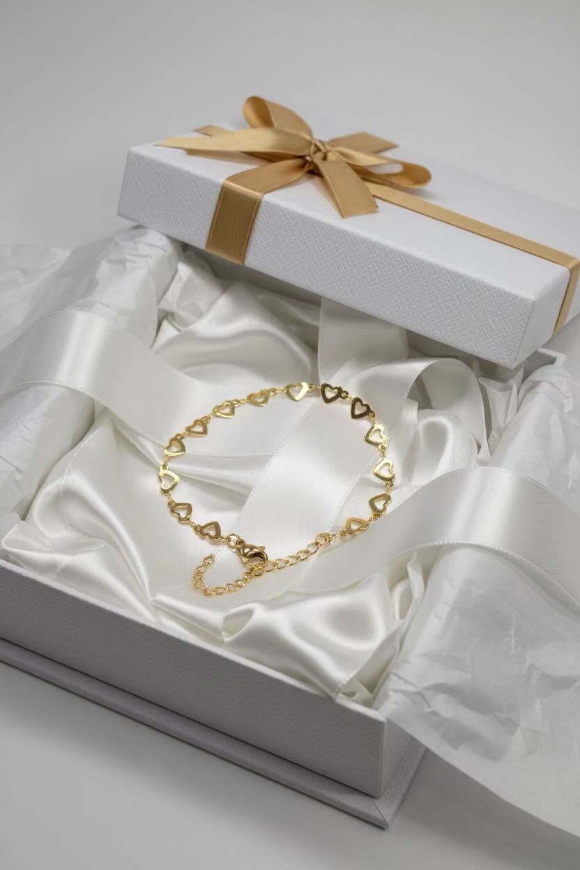 Gold heart-shaped bracelet in a white box with a gold ribbon