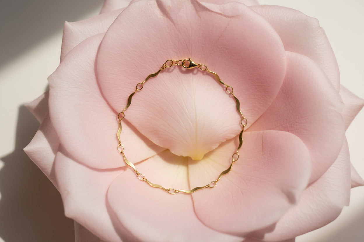Gold bracelet on a pale pink petal 
