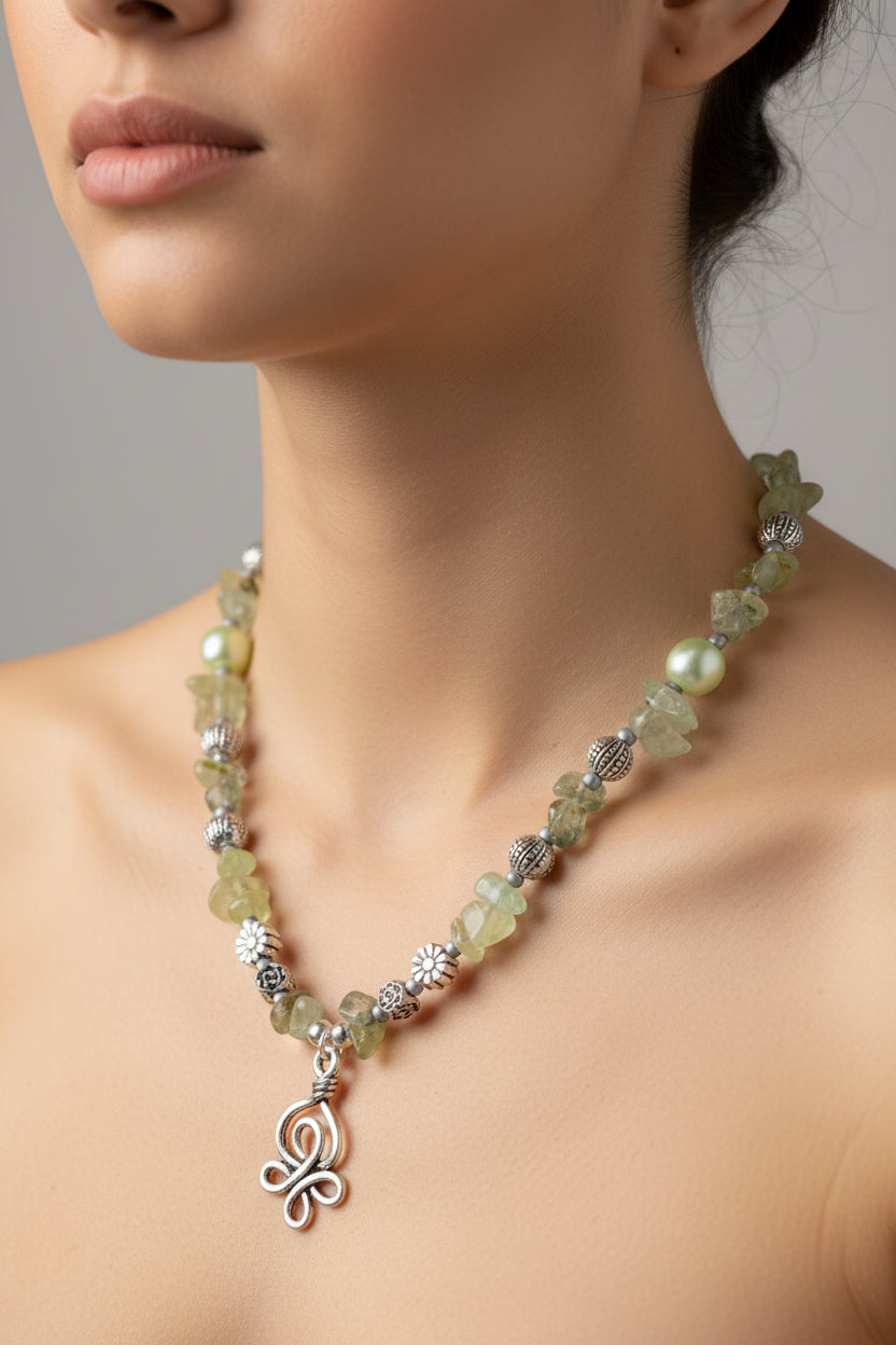 Necklace with green pearls & stones and a silver pendant on a model against a neutral background
