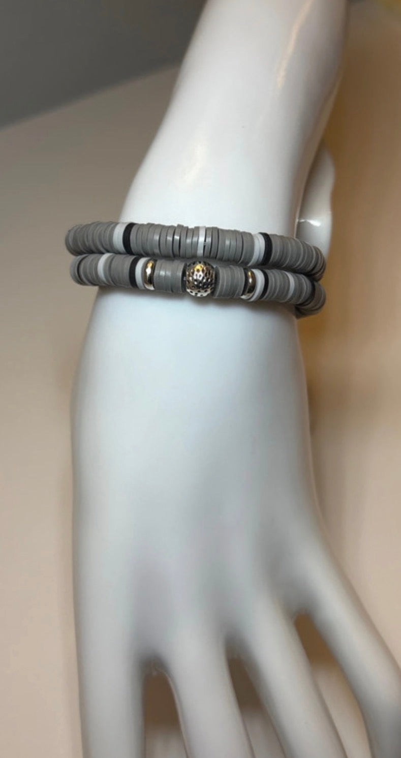 Gray and black patterned bracelet on a mannequin wrist with a neutral background