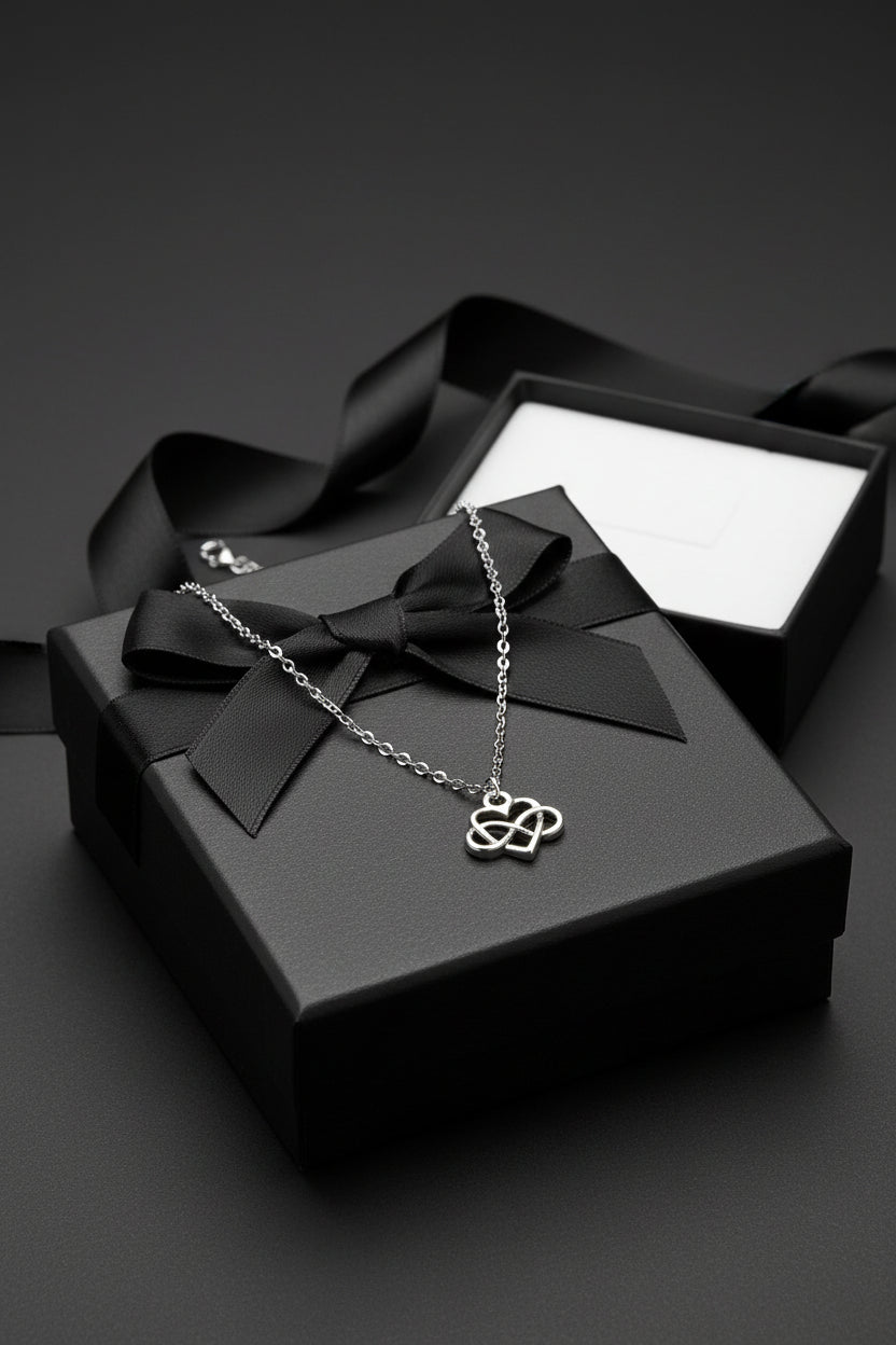 Silver necklace with a heart-shaped pendant on a large black gift box