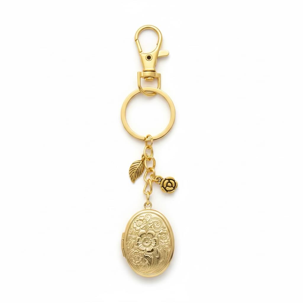A gold-toned metal keyring featuring a lobster clasp, a split key ring, an oval flowered locket, and a small rose charm, shown on a plain white background.