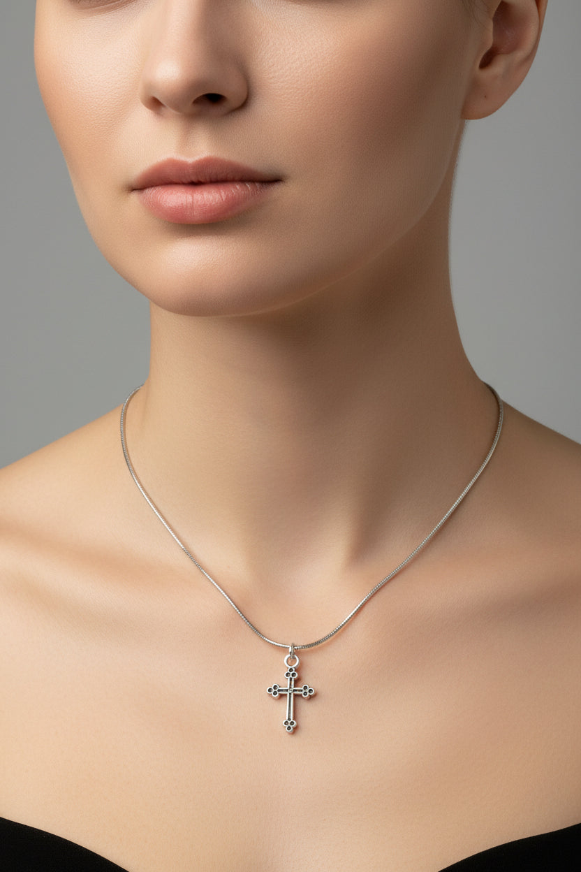 Silver snake chain cross necklace on a model