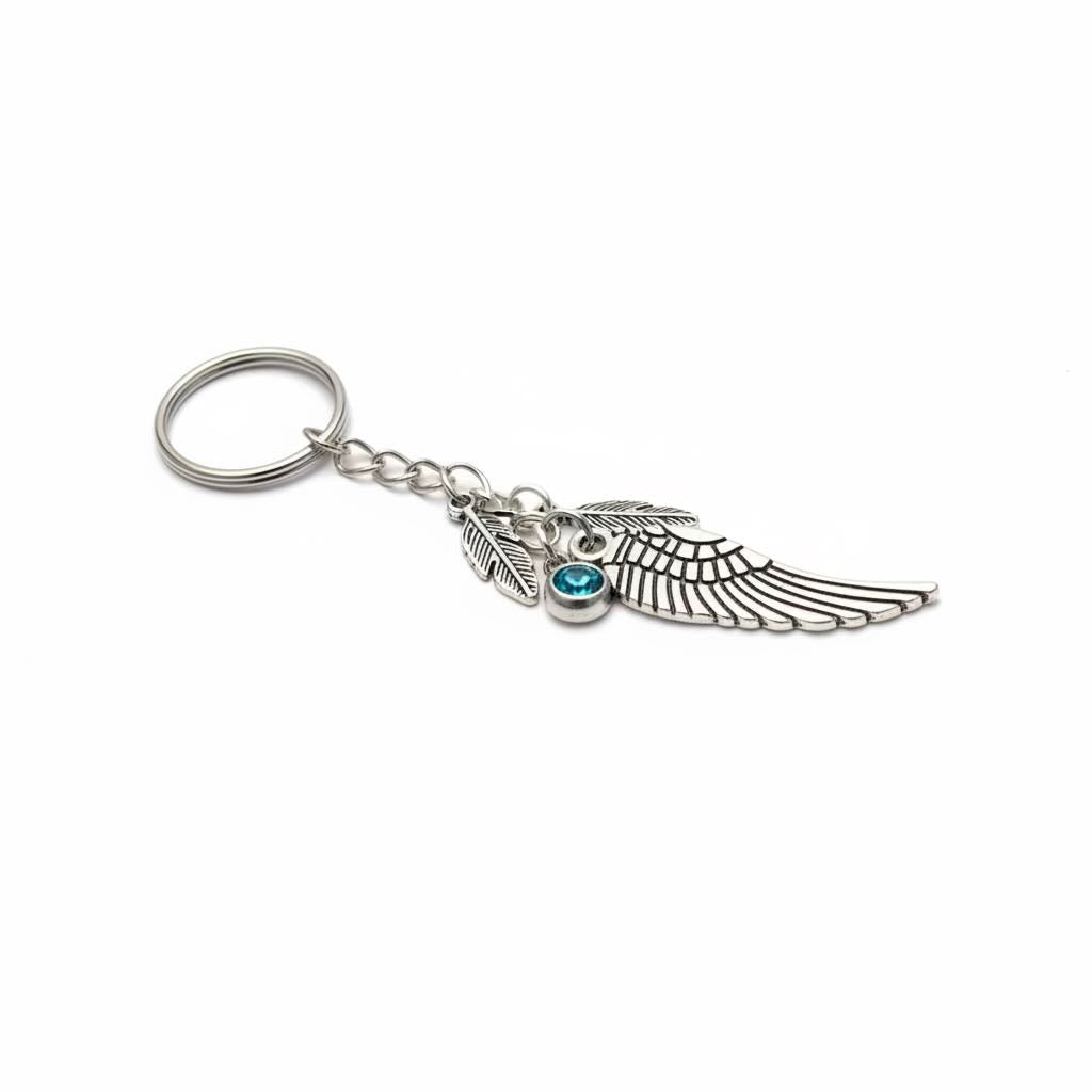 A silver-toned metal angel wing keyring/keyrings with a small blue gemstone accent, shown on a plain white background.