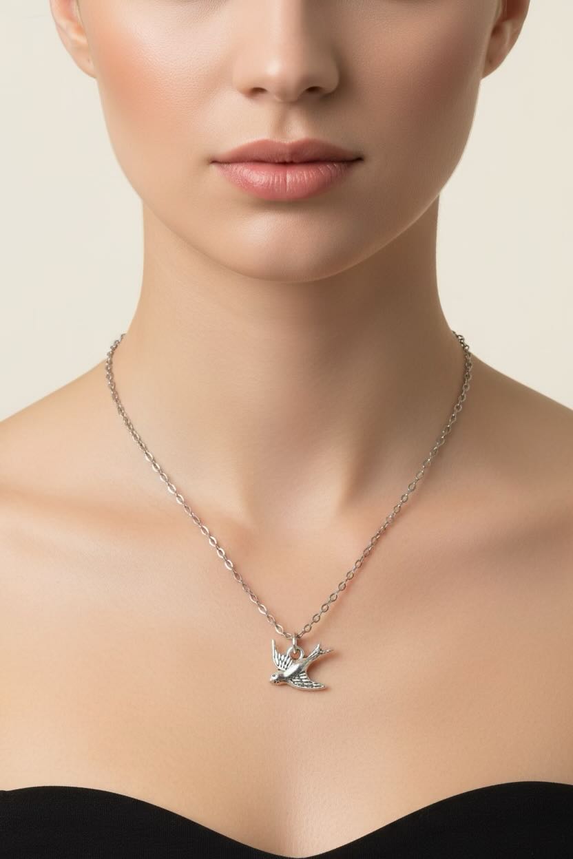 Necklace with a bird pendant worn by a model on a neutral background