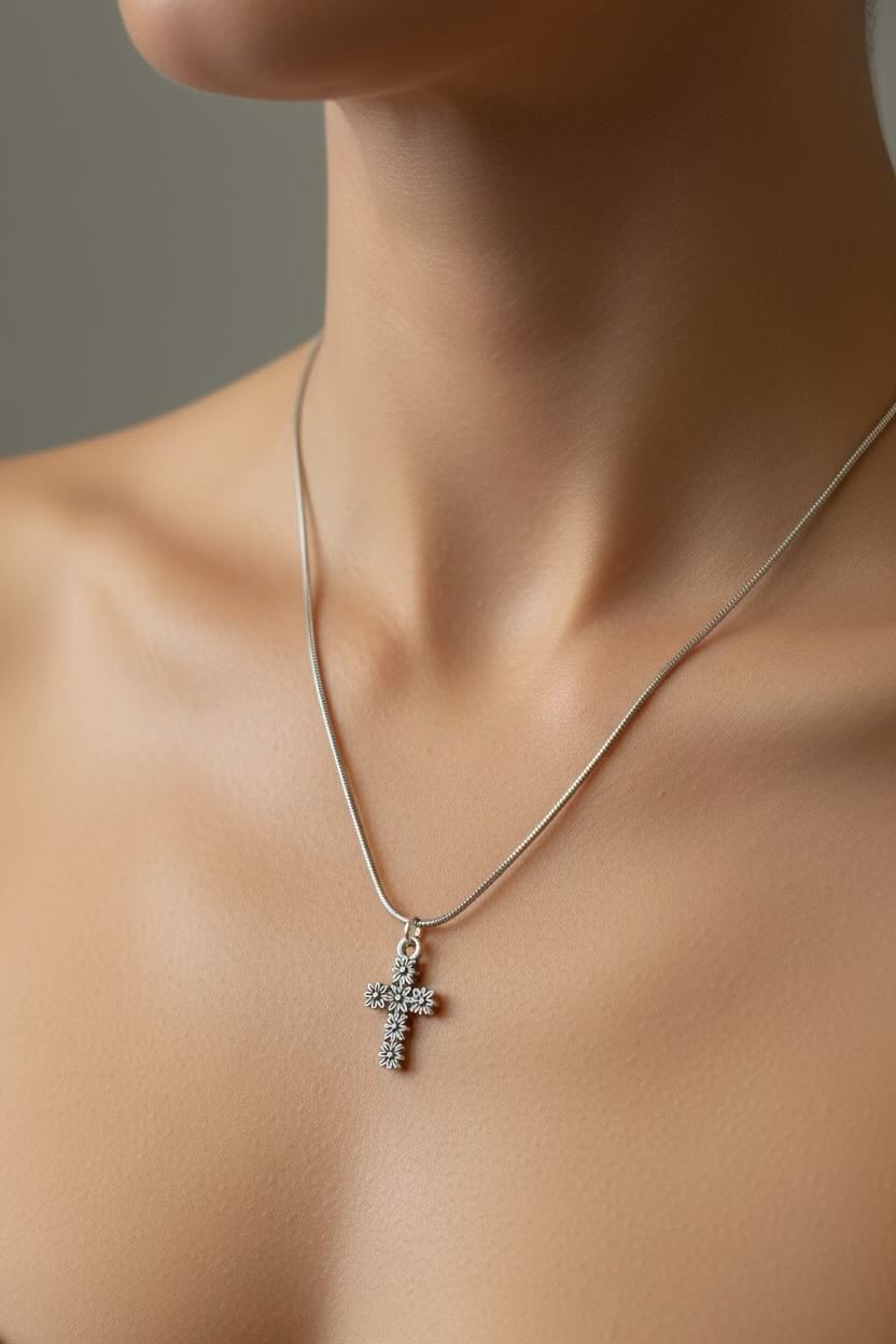 Silver necklace with a cross pendant on a neutral background
