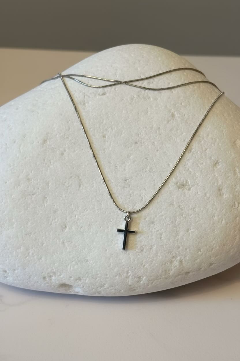 Silver necklace with a cross pendant on a large white stone