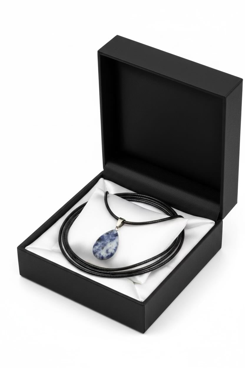 A black coiled cord necklace with a blue and white teardrop pendant, presented inside an open black gift box with a white insert on a white background.