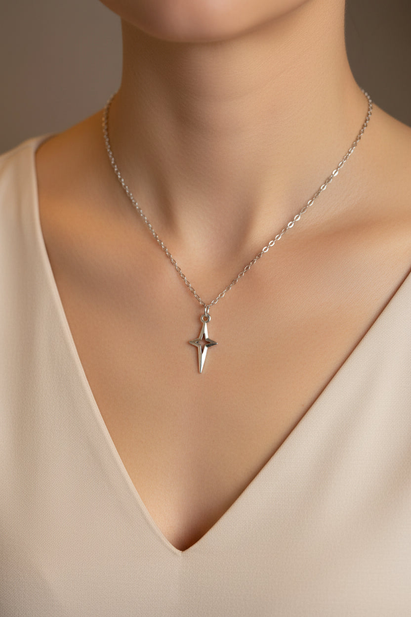 Silver necklace with a star pendant on a model.