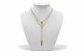 Gold necklace with a pendant on a mannequin bust against a neutral background