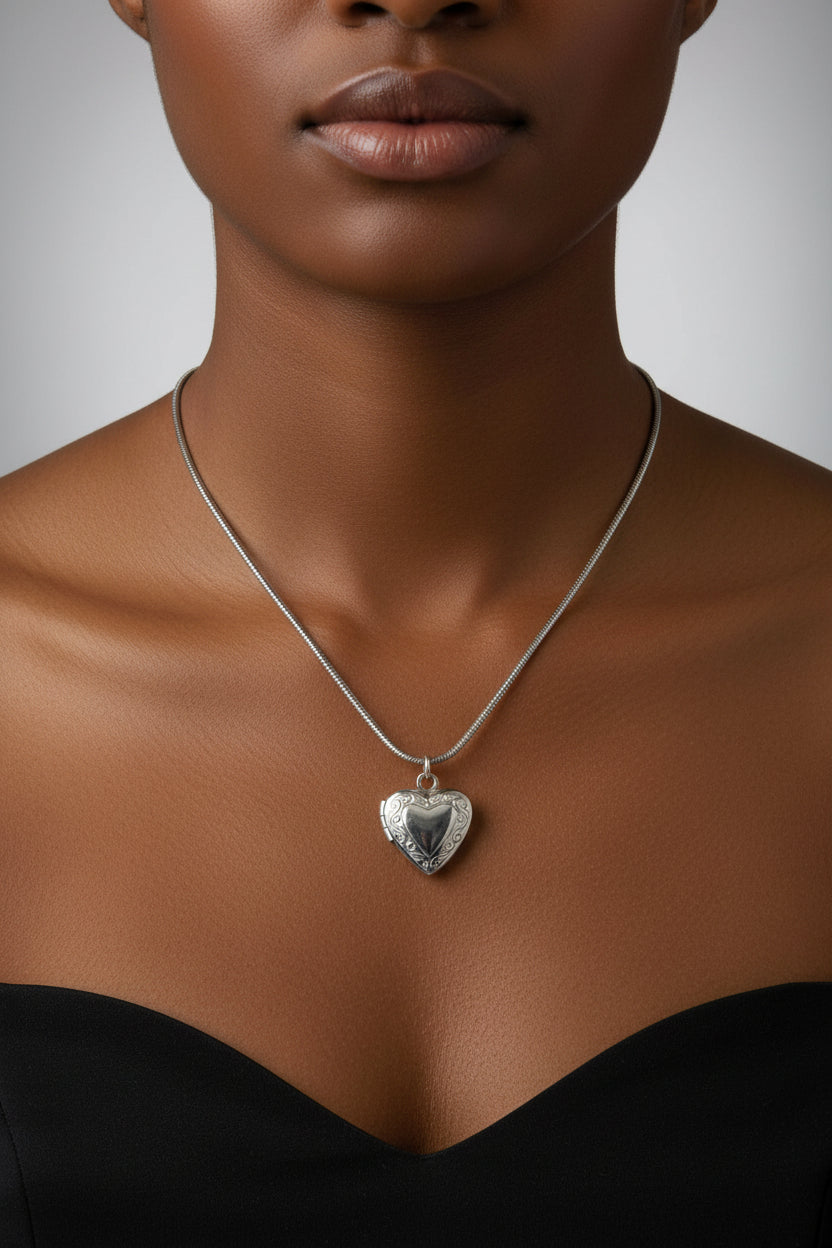Silver heart-shaped pendant on a model wearing a black top.