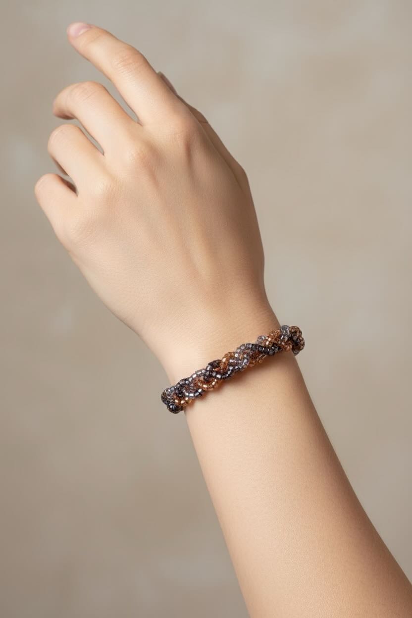 Hand wearing a bracelet on a plain background
