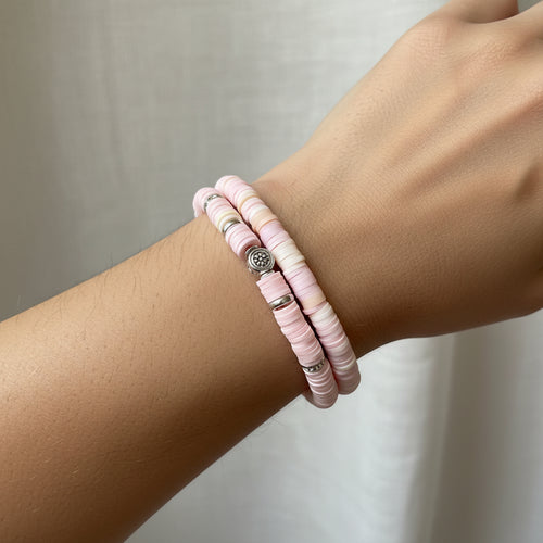Pink beaded bracelet set on a white model's arm