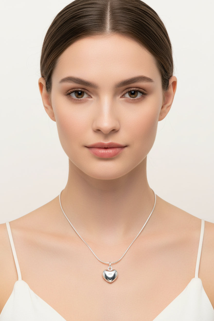 Model wearing sterling silver snake chain necklace with solid heart pendant