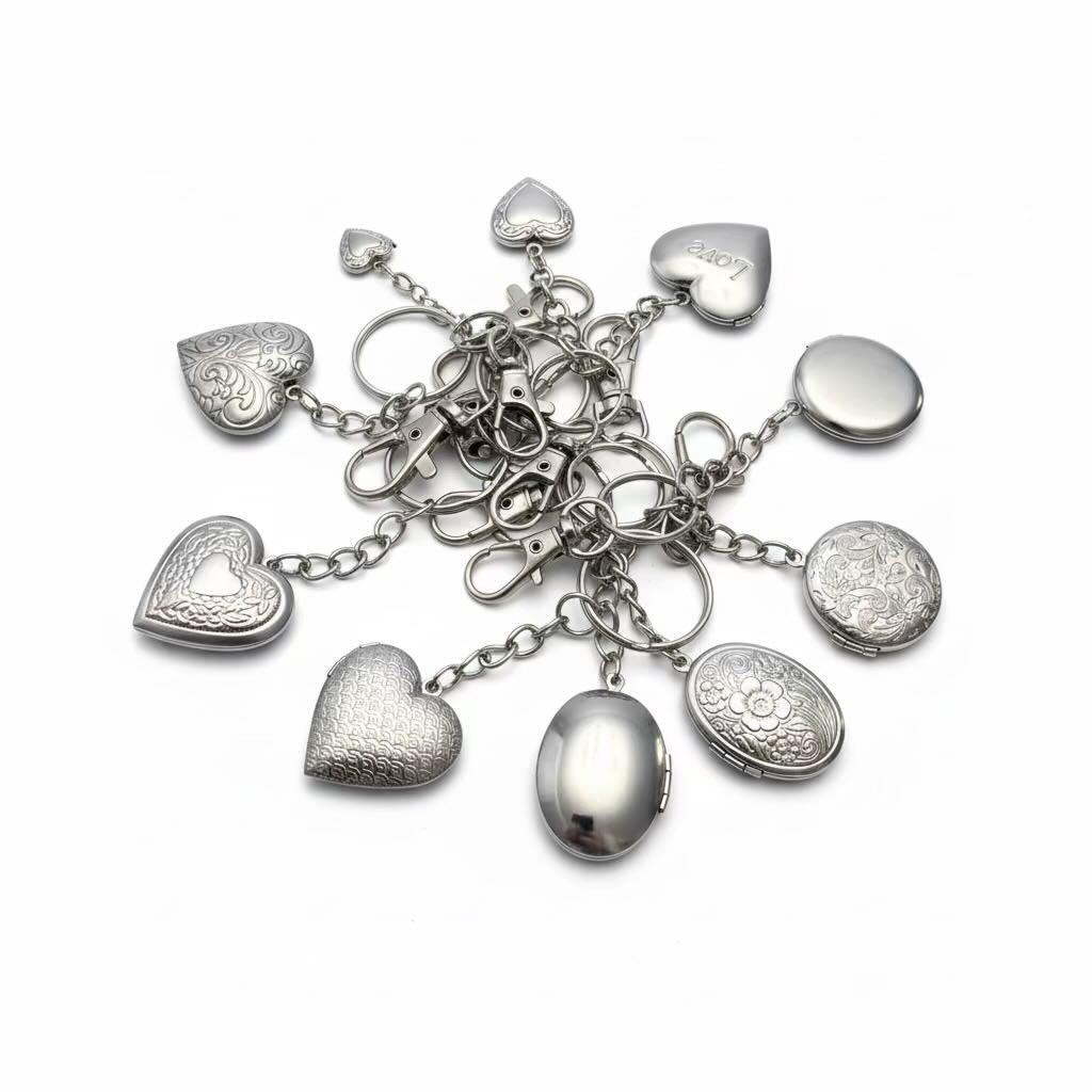 A set of silver-toned heart and oval locket charms with floral engravings and lobster clasps, arranged on a plain white background.