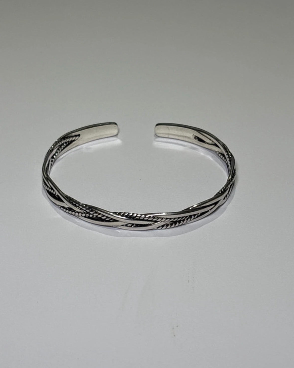 Silver bracelet on a light gray background