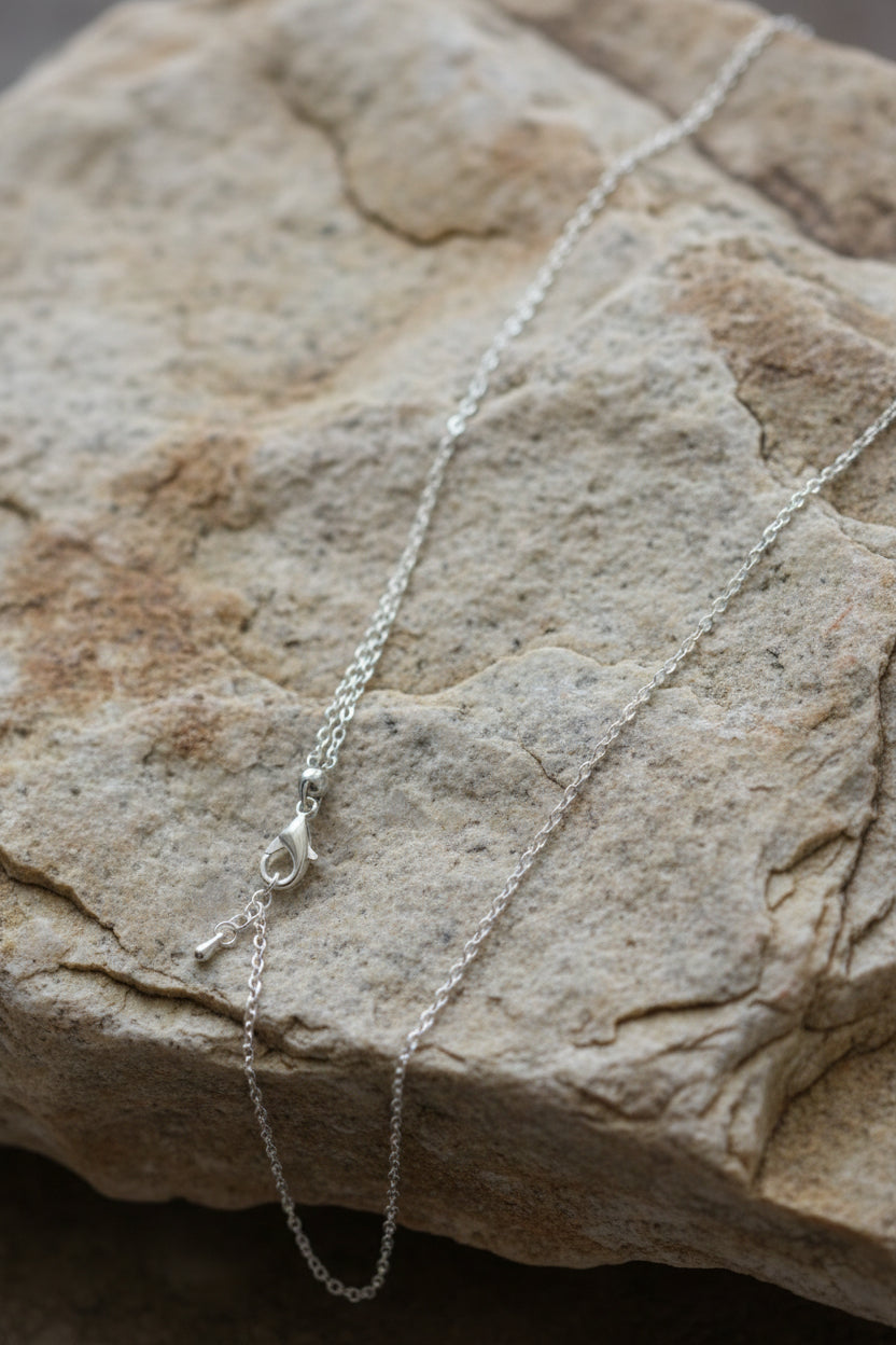 Silver chain necklace on a gray background
