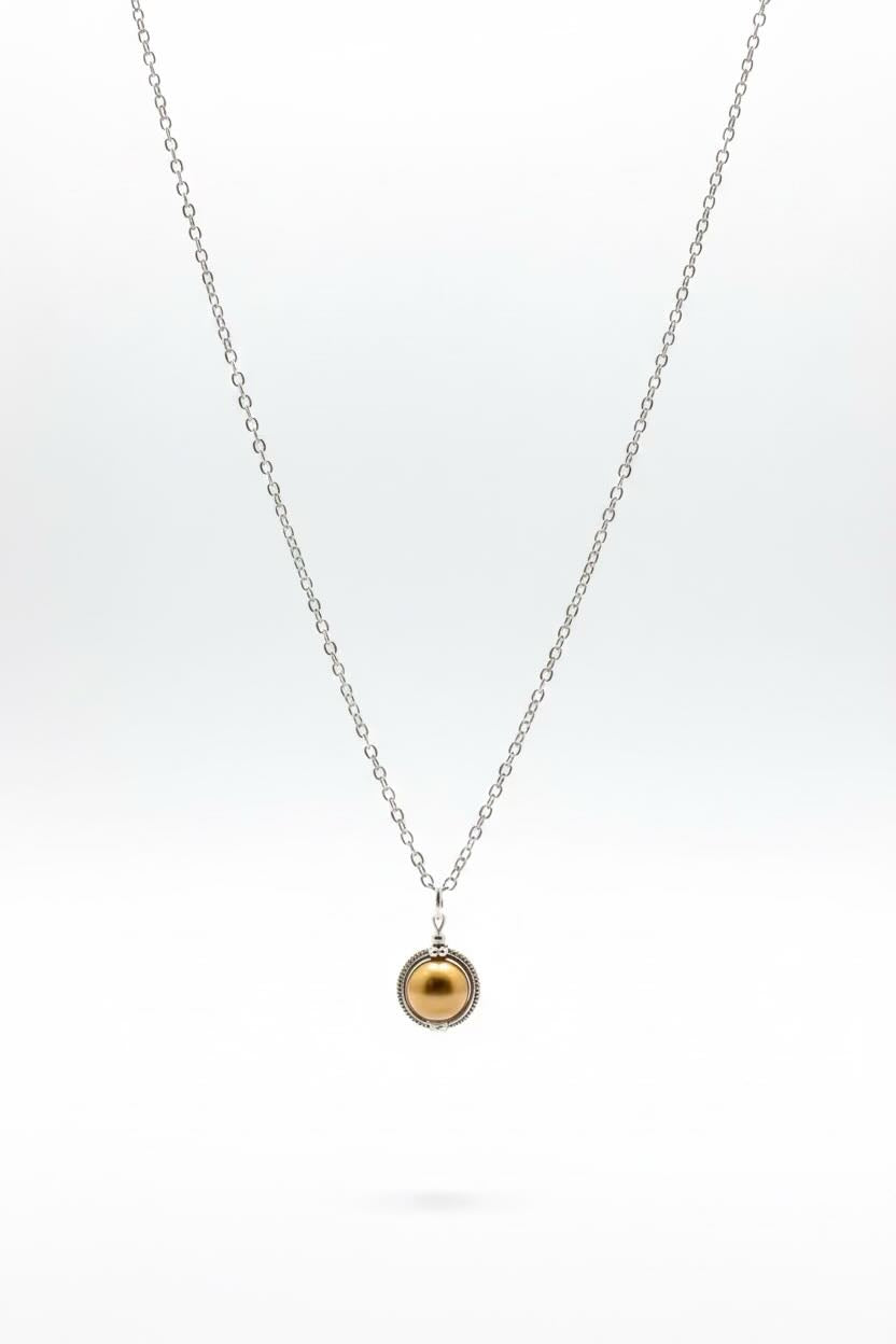 A delicate silver chain necklace with a small gold pearl pendant, displayed against a clean white background.