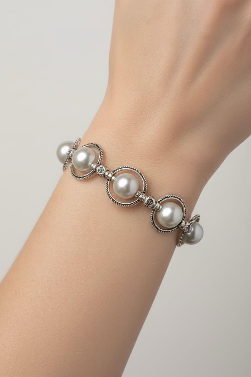 Pearl bracelet on a wrist against a neutral background