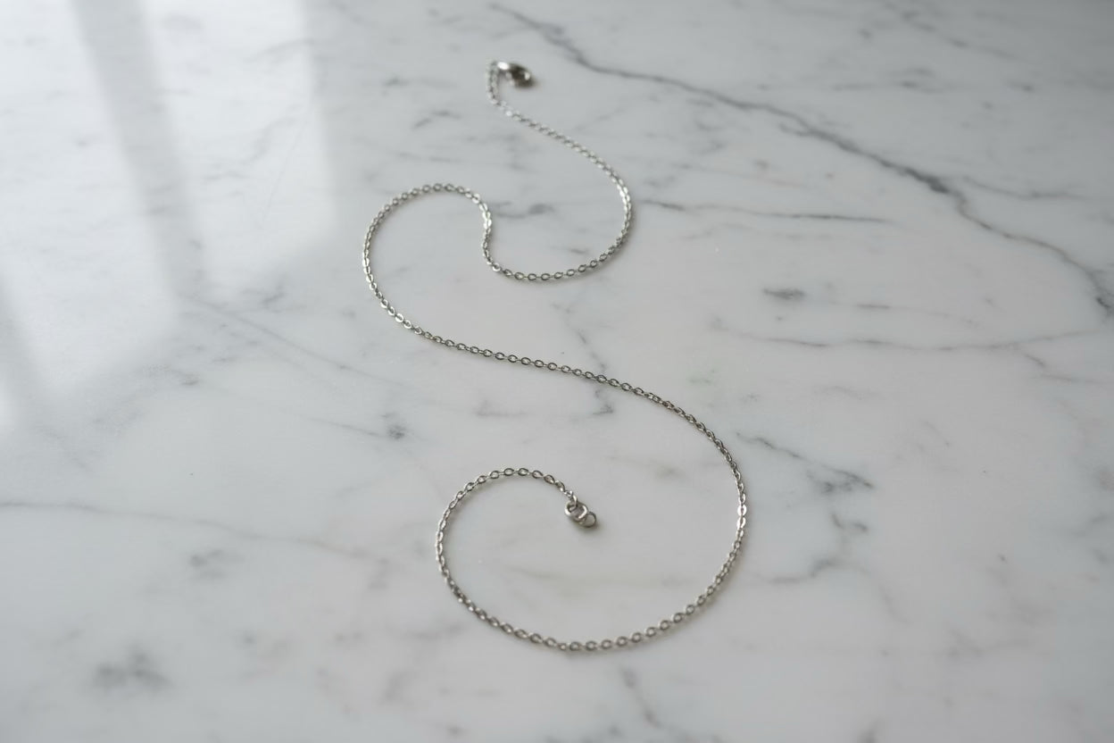 Silver chain necklace on a marble surface